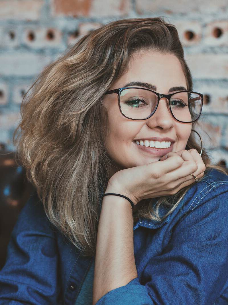 Kaya, smiling, resting her chin on her hand